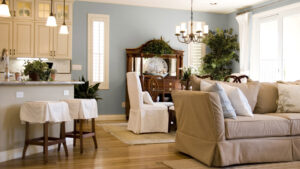 Living room with seafoam-blue walls and beige window trim and baseboards