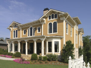 Modern two-story home with Victorian influences, tan lap siding and white trim