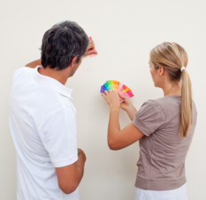 Couple choosing a color to paint a room after move in